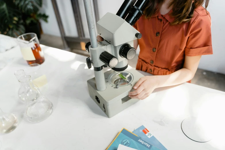 a girl looking through a microscope in the sun