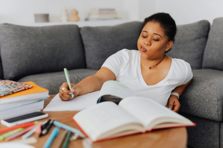 a woman sitting on top of a couch in front of a book