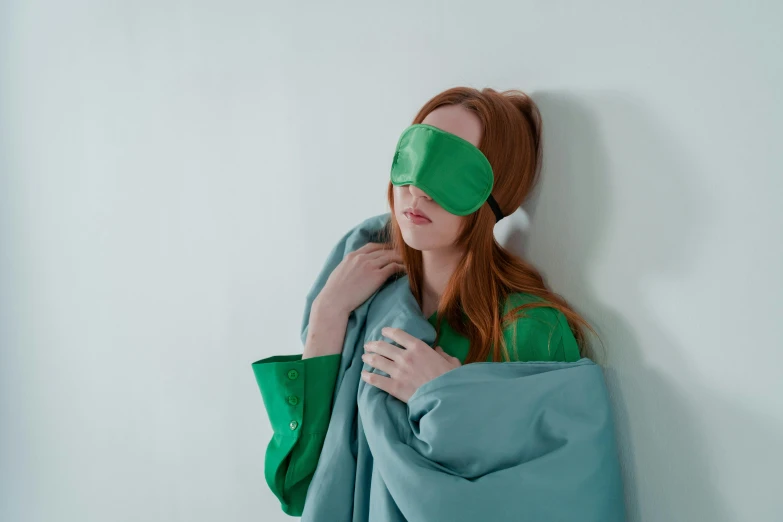 a girl with blindfolds is hiding her eyes behind a blanket