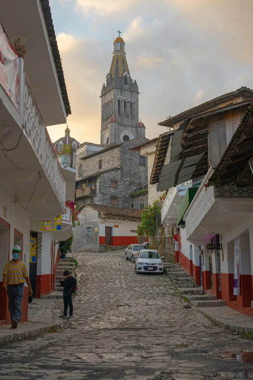 a cobblestone street with some buildings and cars