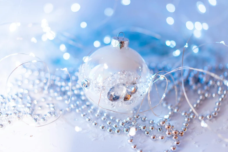 a glass bauble is laying next to a string of pearls