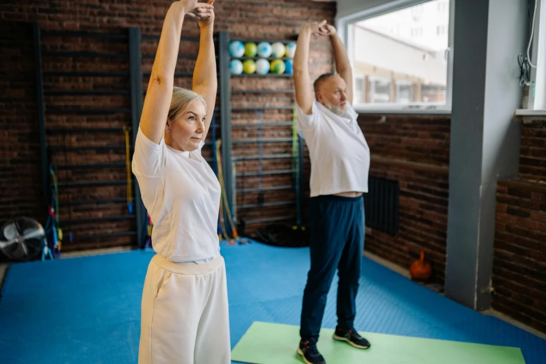 two people standing on mats and stretching