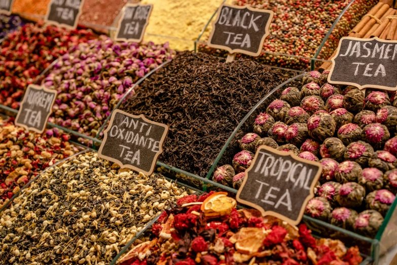 spices and herbs arranged in different bins at a market