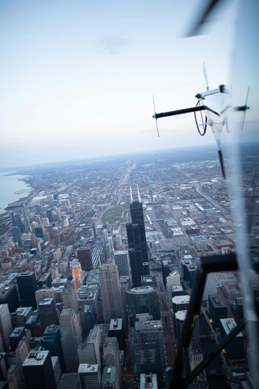 an air plane flying over a city with tall buildings