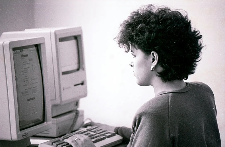 black and white pograph of a woman at a computer