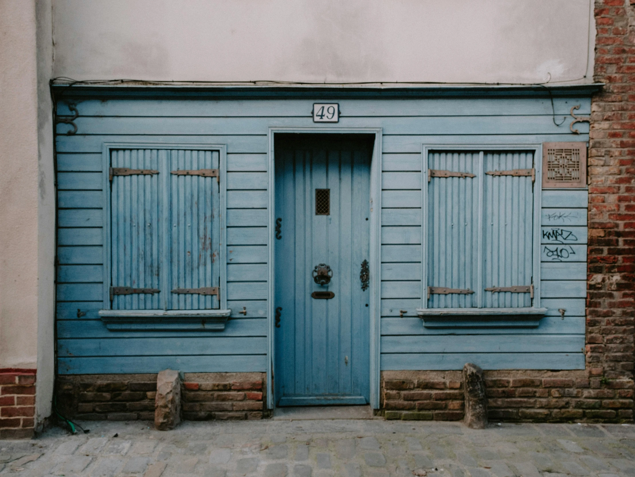 a small building with two doors and a window