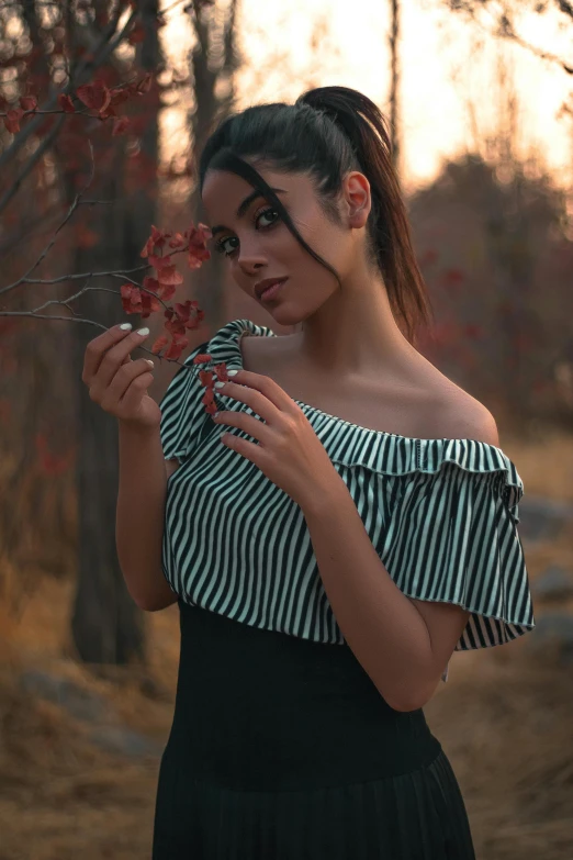 a woman in a striped top holding flowers