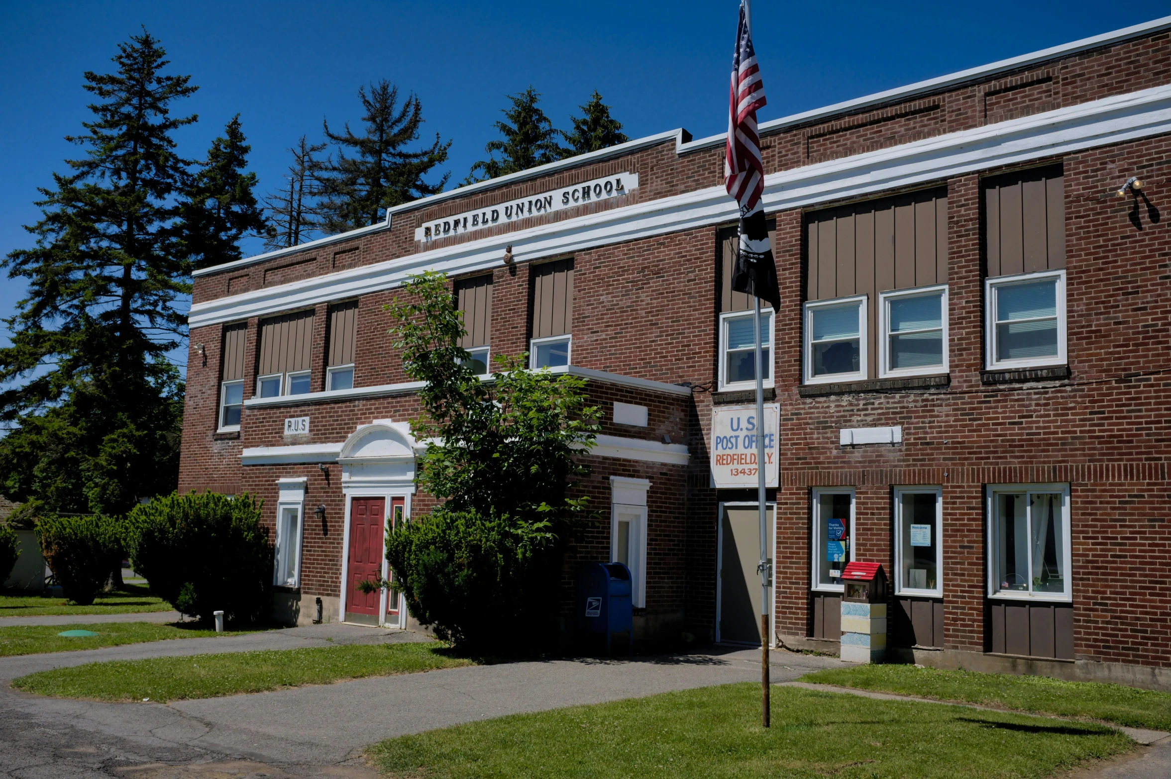 a brick building is on a corner with a flag pole