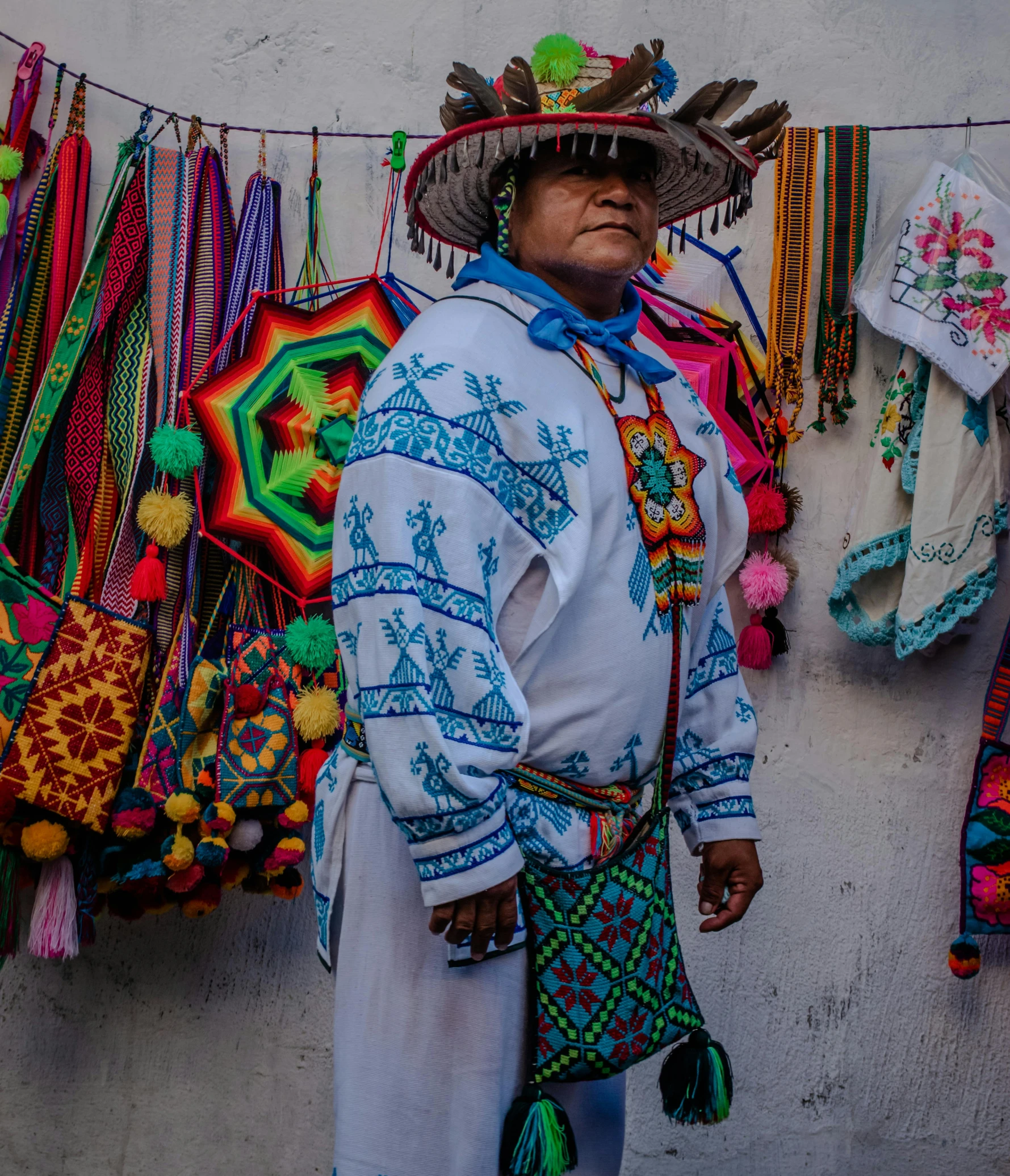 a woman is standing in front of a lot of colorful material