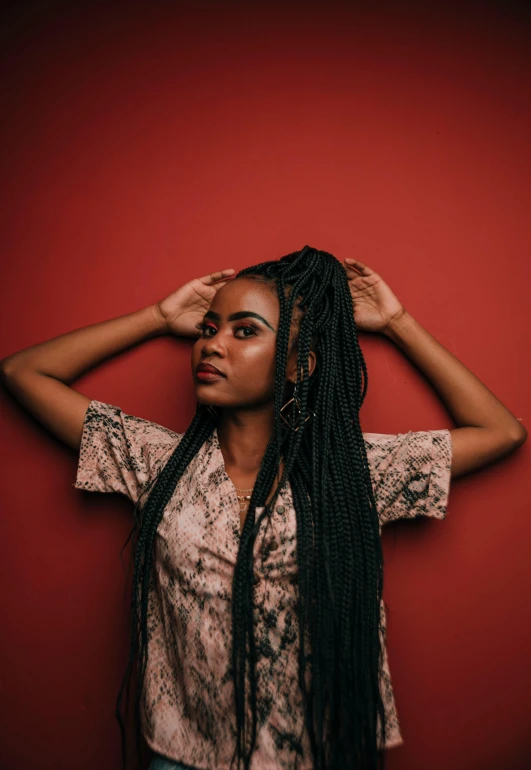 young woman with long black hair against red wall