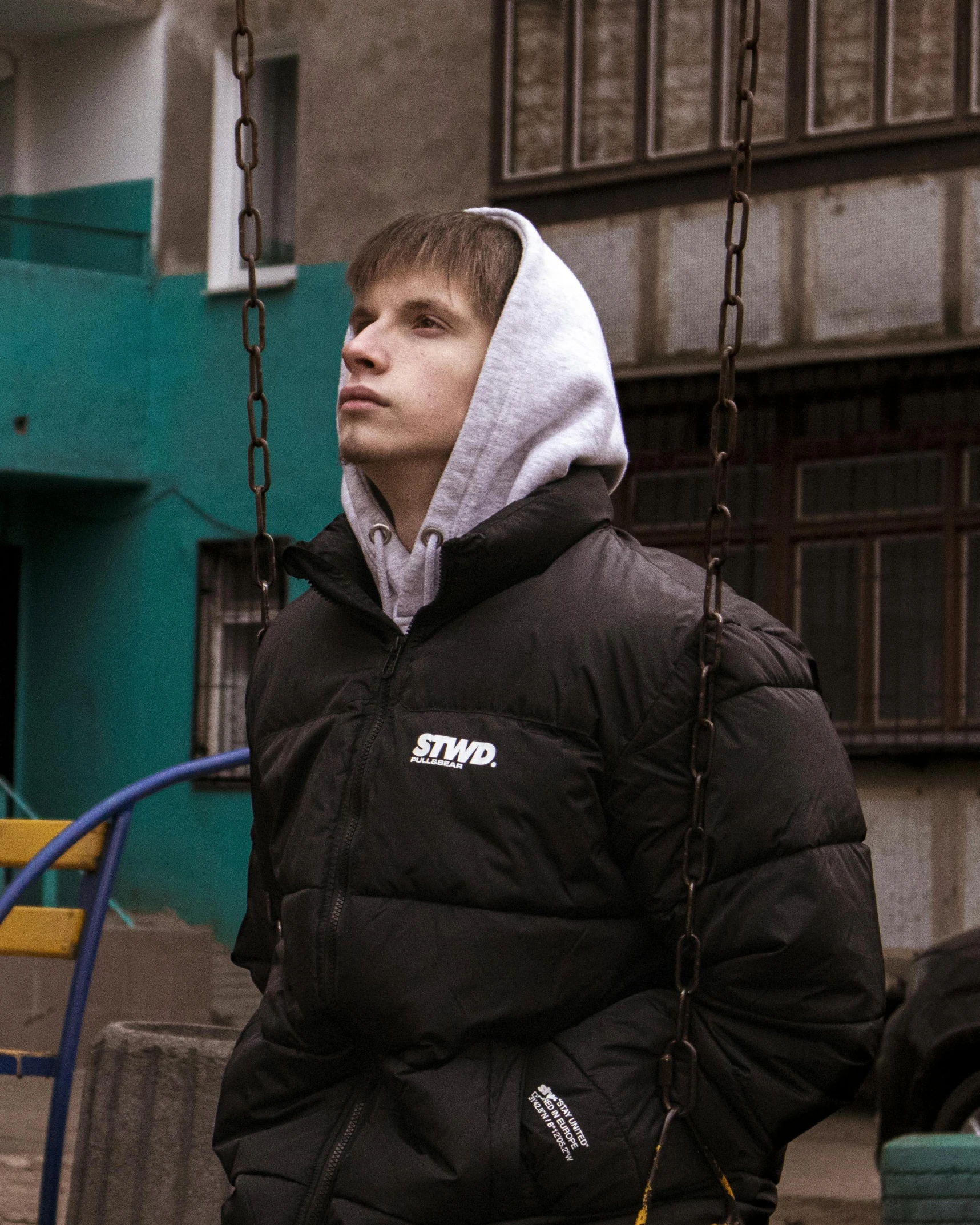 a man in a hoodie on a swing