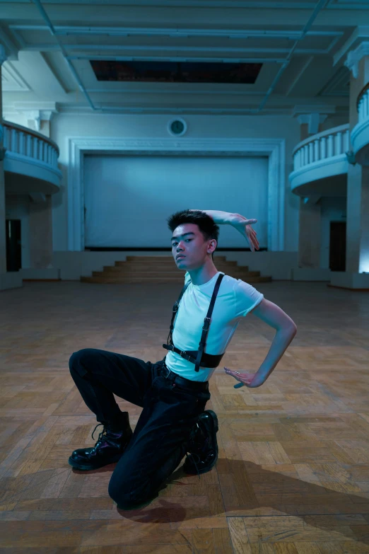 a young man in black suspenders is posing for the camera