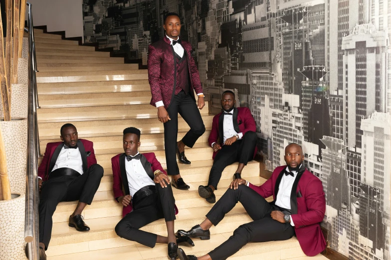 five guys in tuxedos pose on some steps