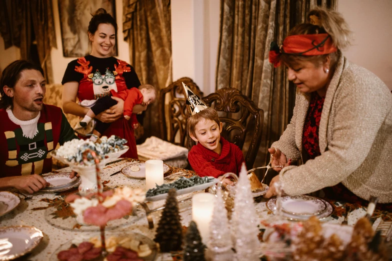 people wearing christmas attire standing around a dinner table