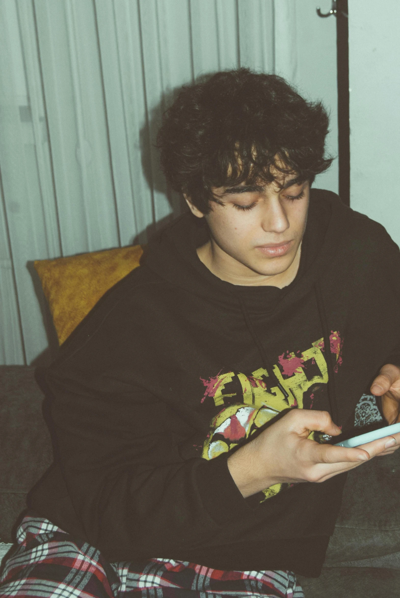 a young man in pajamas looking at his phone