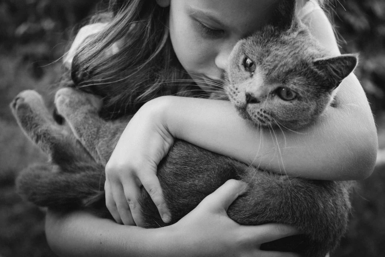 a girl holding her cat in black and white