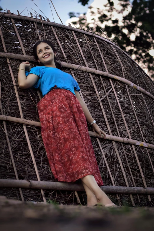 a girl posing against a wall holding onto a bar