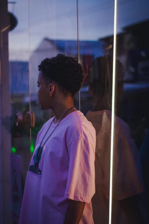 a woman stands by her reflection in a glass case