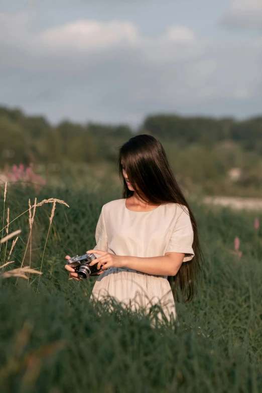 woman with camera in field looking at soing