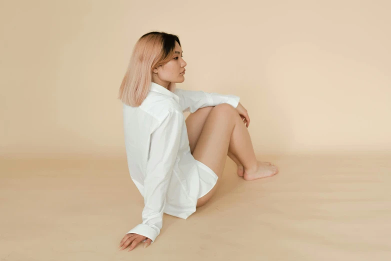 a woman with long hair is posing in a white shirt