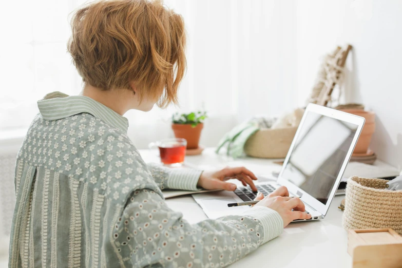 a woman at a desk using a laptop computer