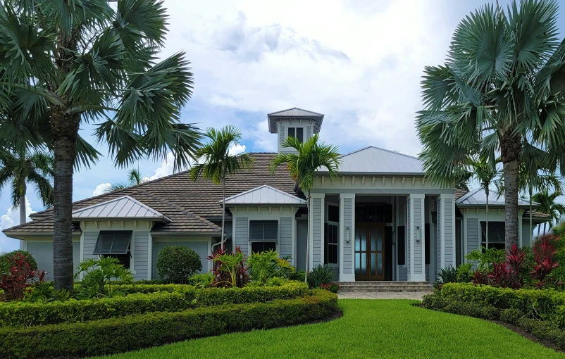 this is an elegant home with trees and plants in front of it