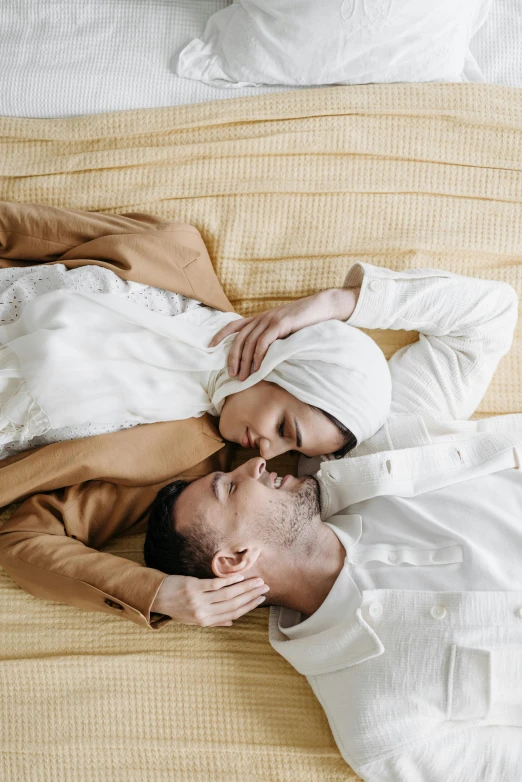 two people who are laying on a bed together