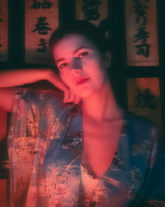 a woman sits in front of a display of chinese writing