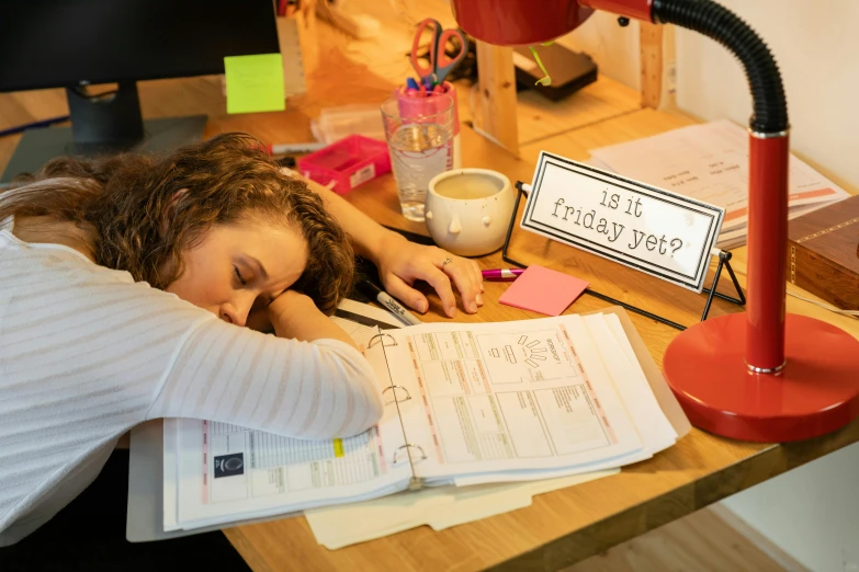 a woman sitting at a desk writing on notes