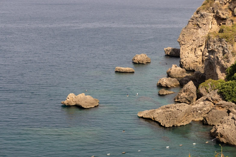 several rocks in the water and one on it