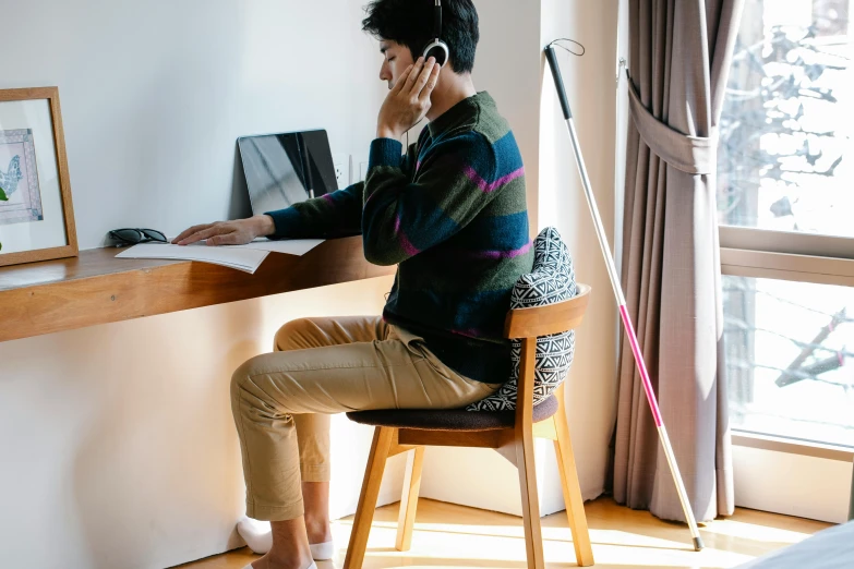 a woman at a desk with her laptop talking on her phone