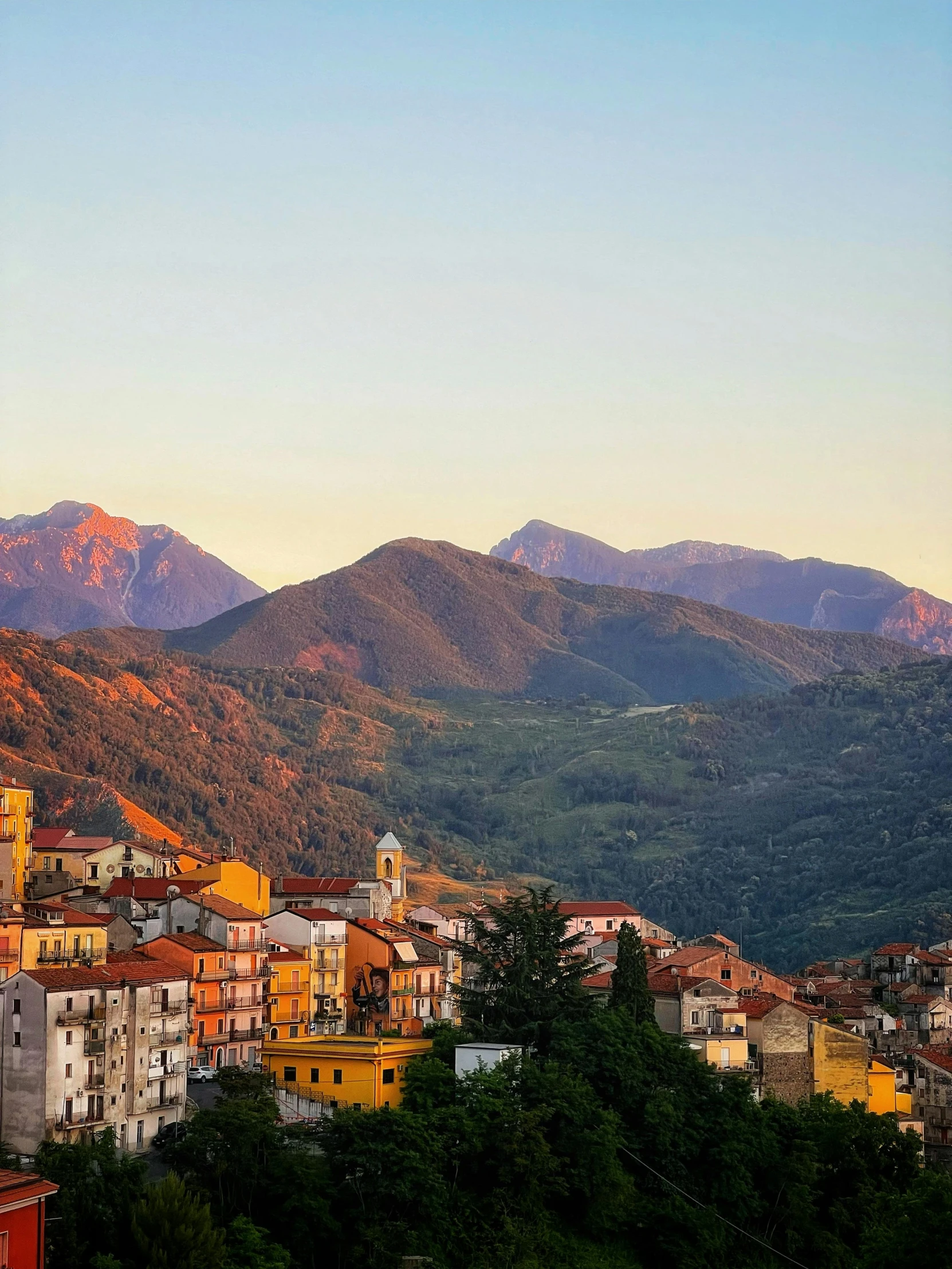 several mountains sit in the distance behind a small town