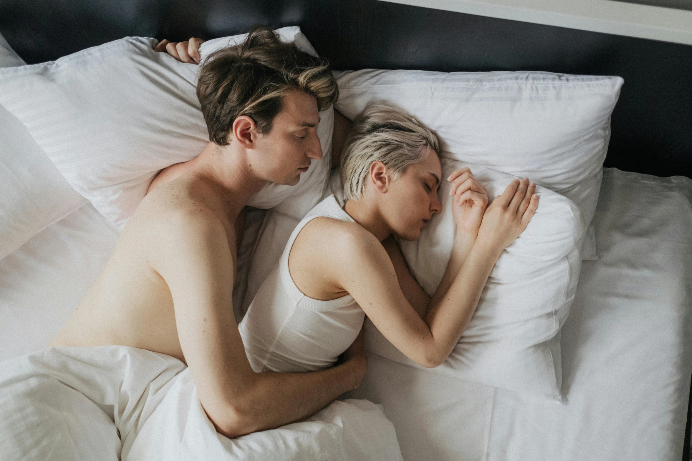 a man and woman cuddled up on a bed