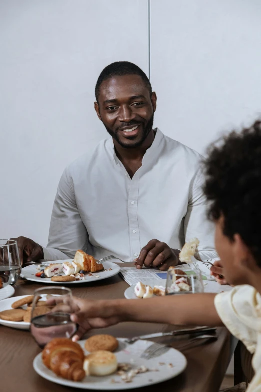 three people sitting at a table with plates of food