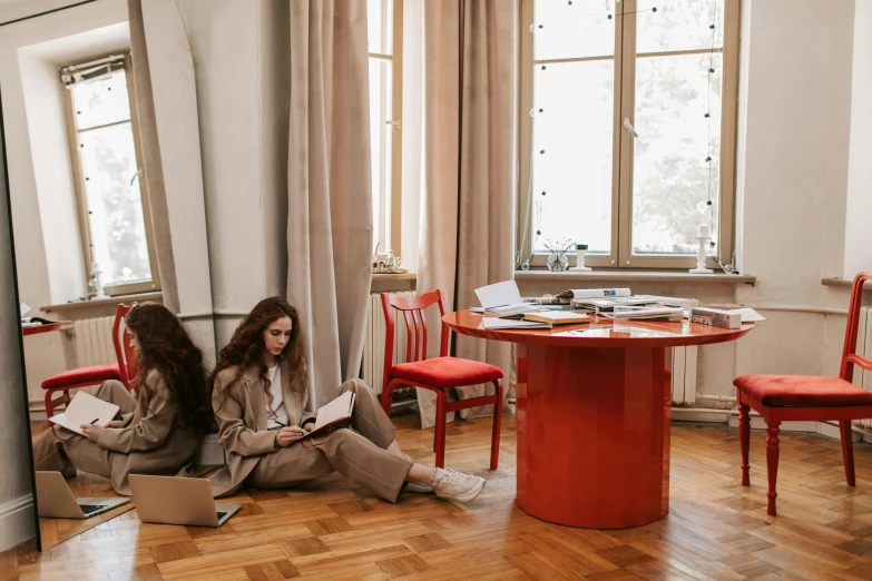 two women sitting on the floor with laptops