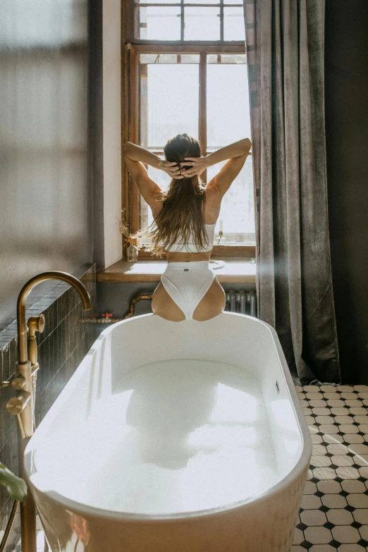 a young lady is sitting in the bathtub in the bathroom