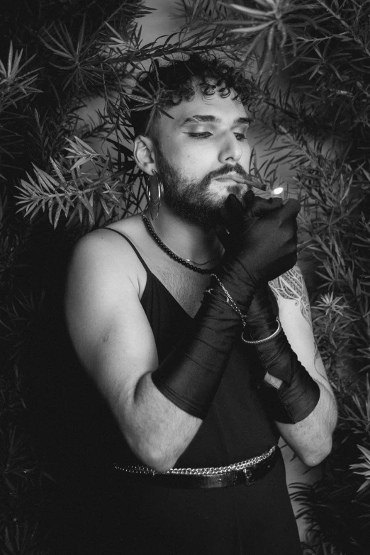 black and white pograph of man dressed in gothic costume smoking a cigarette