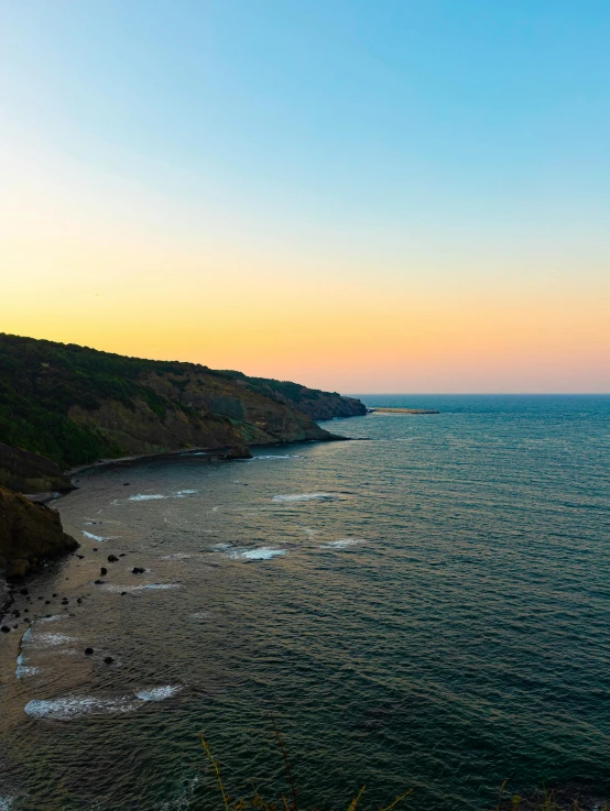 the coast line near an island at sunset