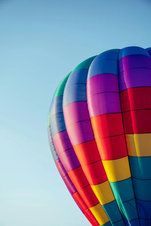  air balloons float on the ground against a blue sky