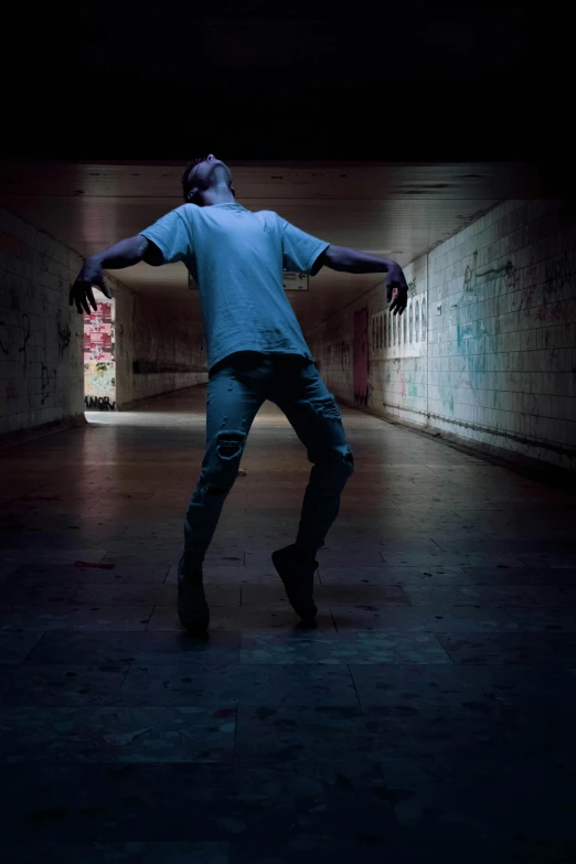 the skateboarder has made his way down an almost empty bricked tunnel