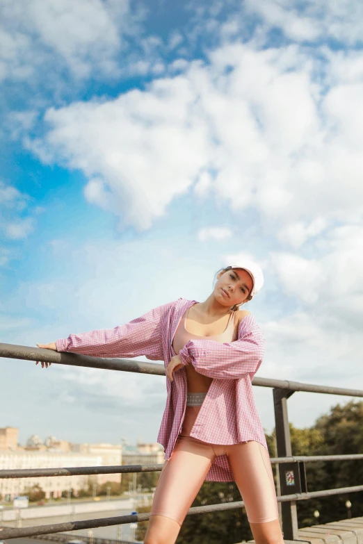 a woman in pink clothes leaning on railing in the air