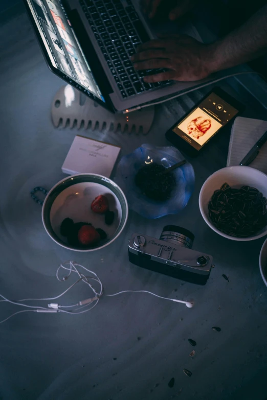 a man is working on his laptop and another coffee cup is beside him