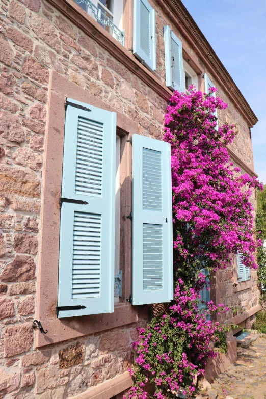 a window with white shutters is in a building