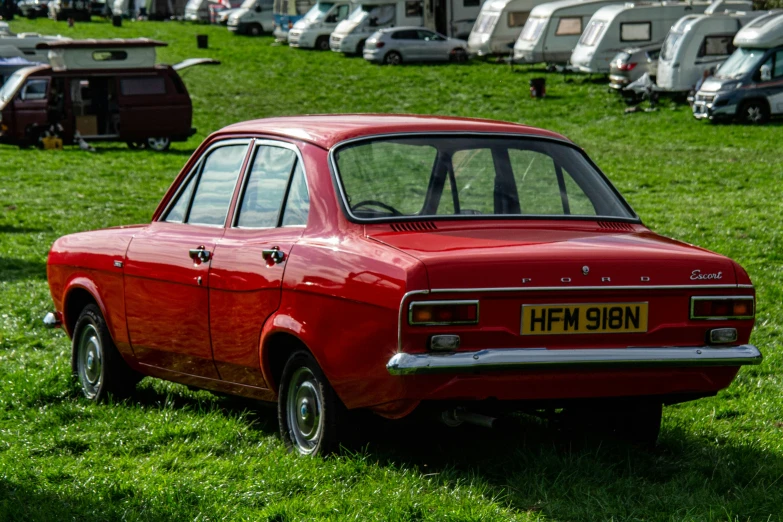 a red car parked in a lush green field