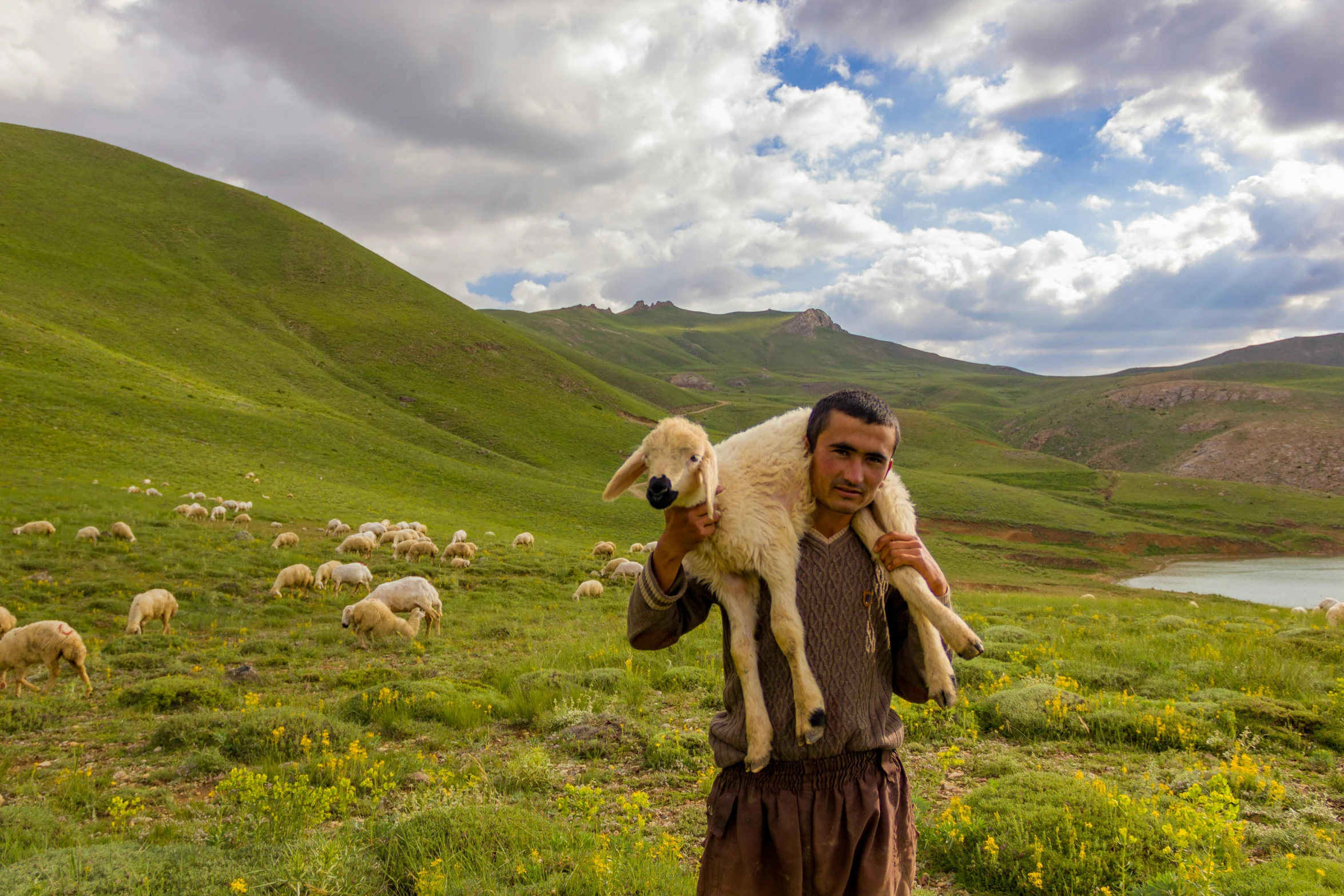 a man in brown clothes holding a dog in his arms