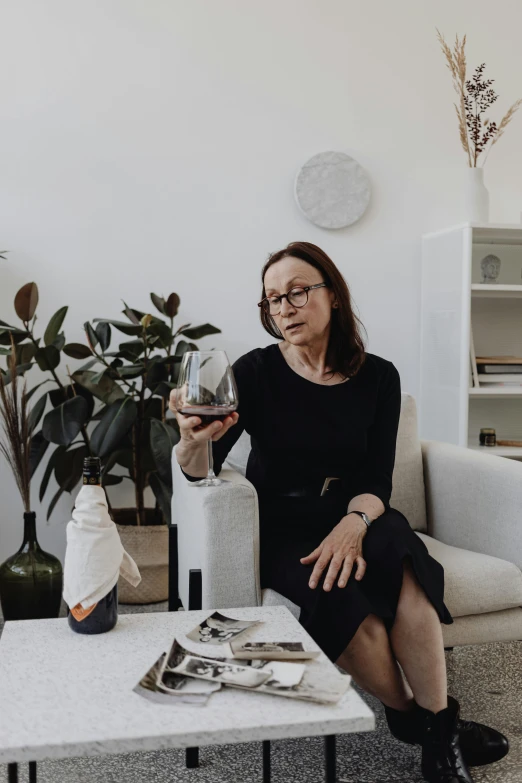 a woman sitting on a couch holding a glass of wine