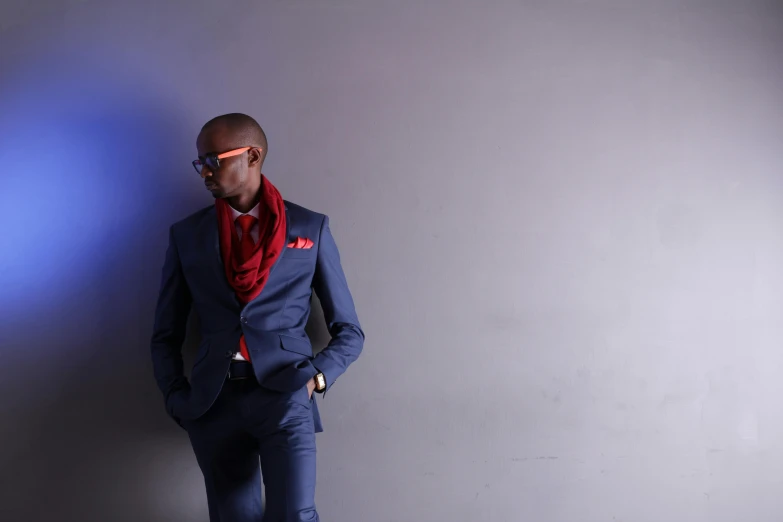 man in suit and red tie standing with his hands on his hips