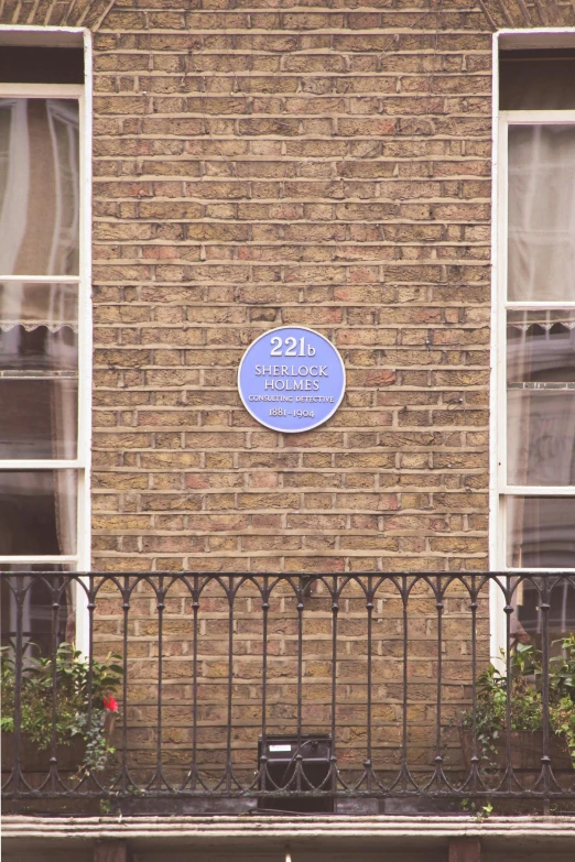 a blue sign is on the brick wall of an apartment building