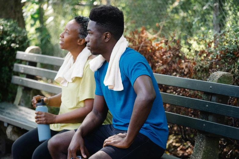 two people are sitting on a bench with their back to the camera