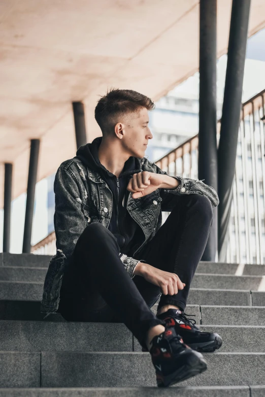 a man sitting on the steps in a stairway with his shoes off